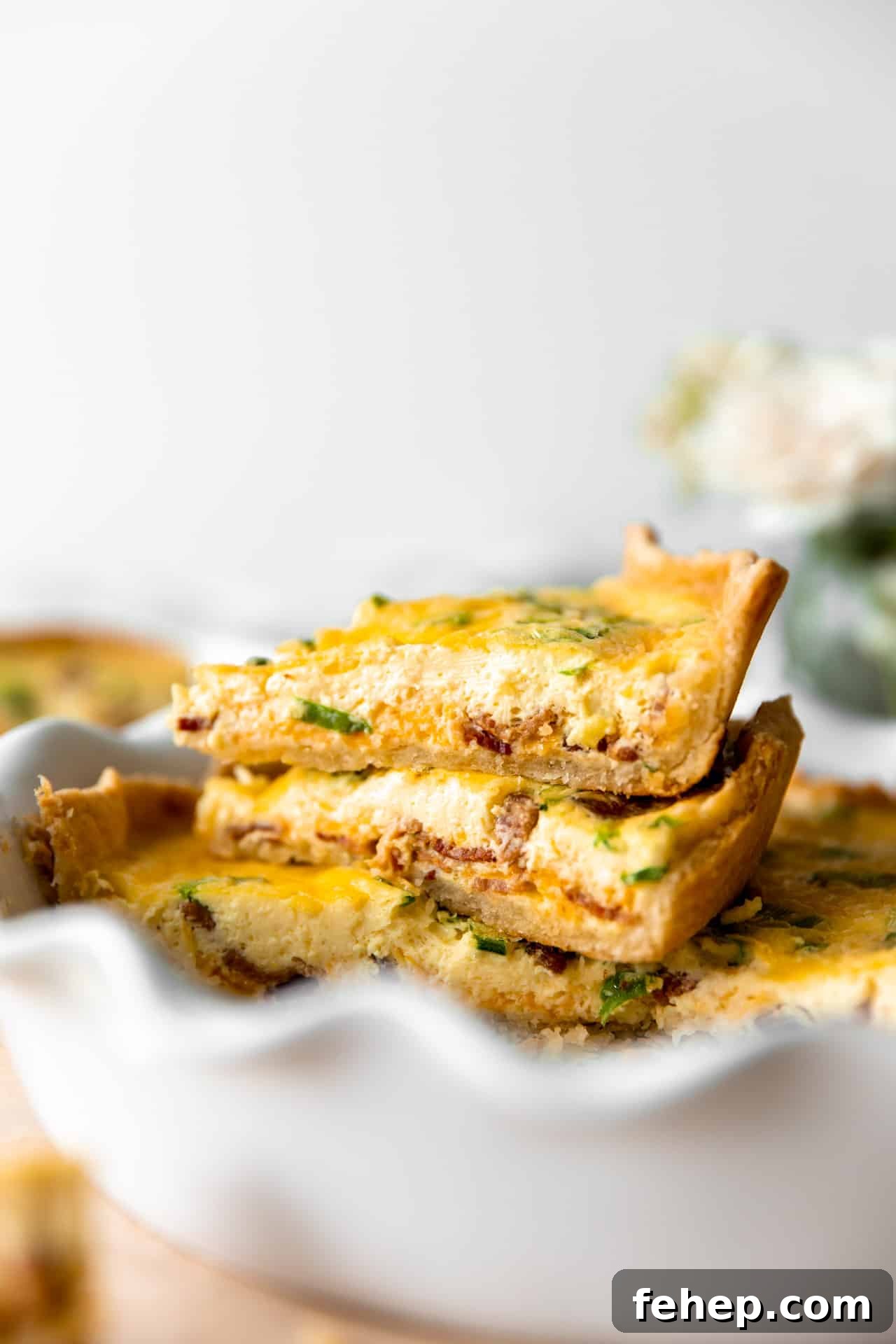 Classic French Quiche Recipe: Flaky Crust and Creamy Filling 11 Stacked up slices of quiche in a pie dish.