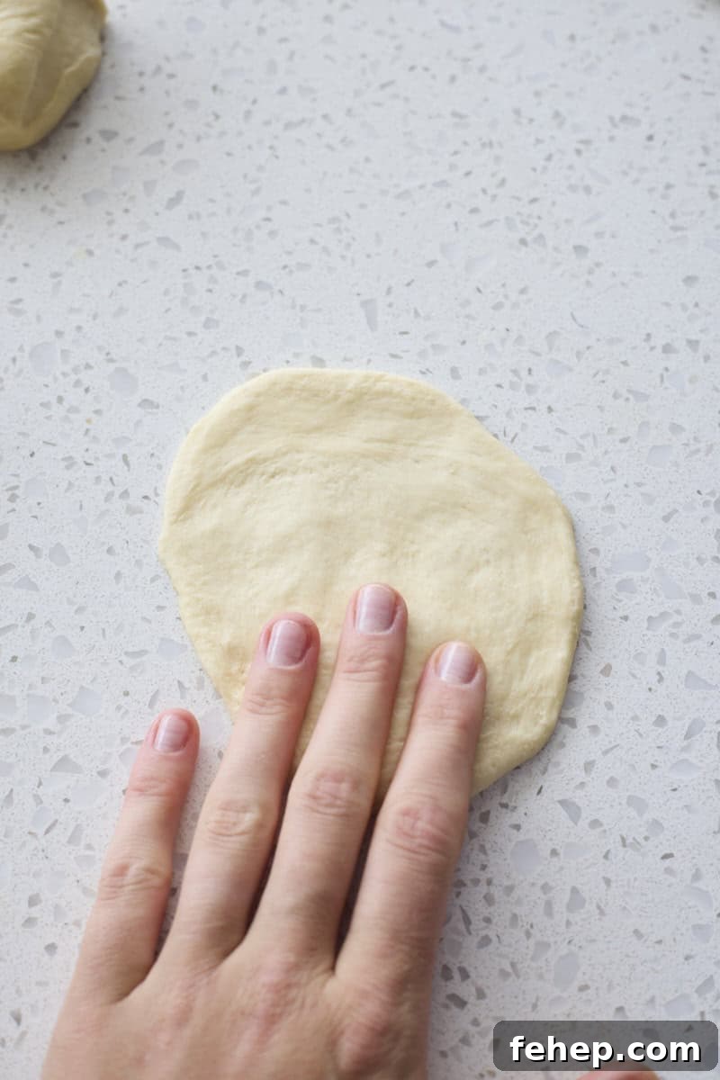 Dough piece flattened by hand.