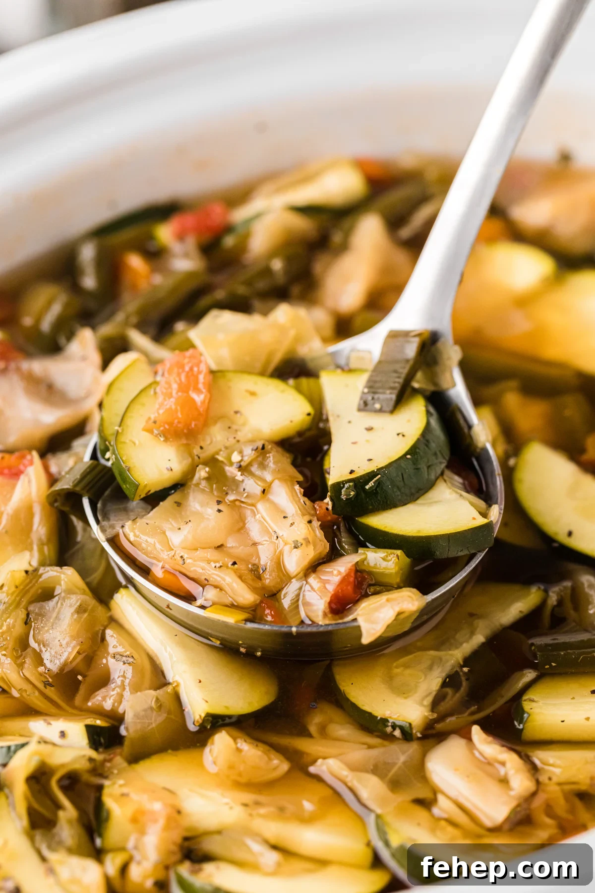 Close-up of slow cooker weight loss soup with a ladle.