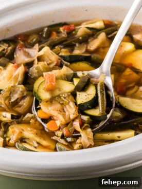 A ladle scooping out some slow cooker weight loss soup.