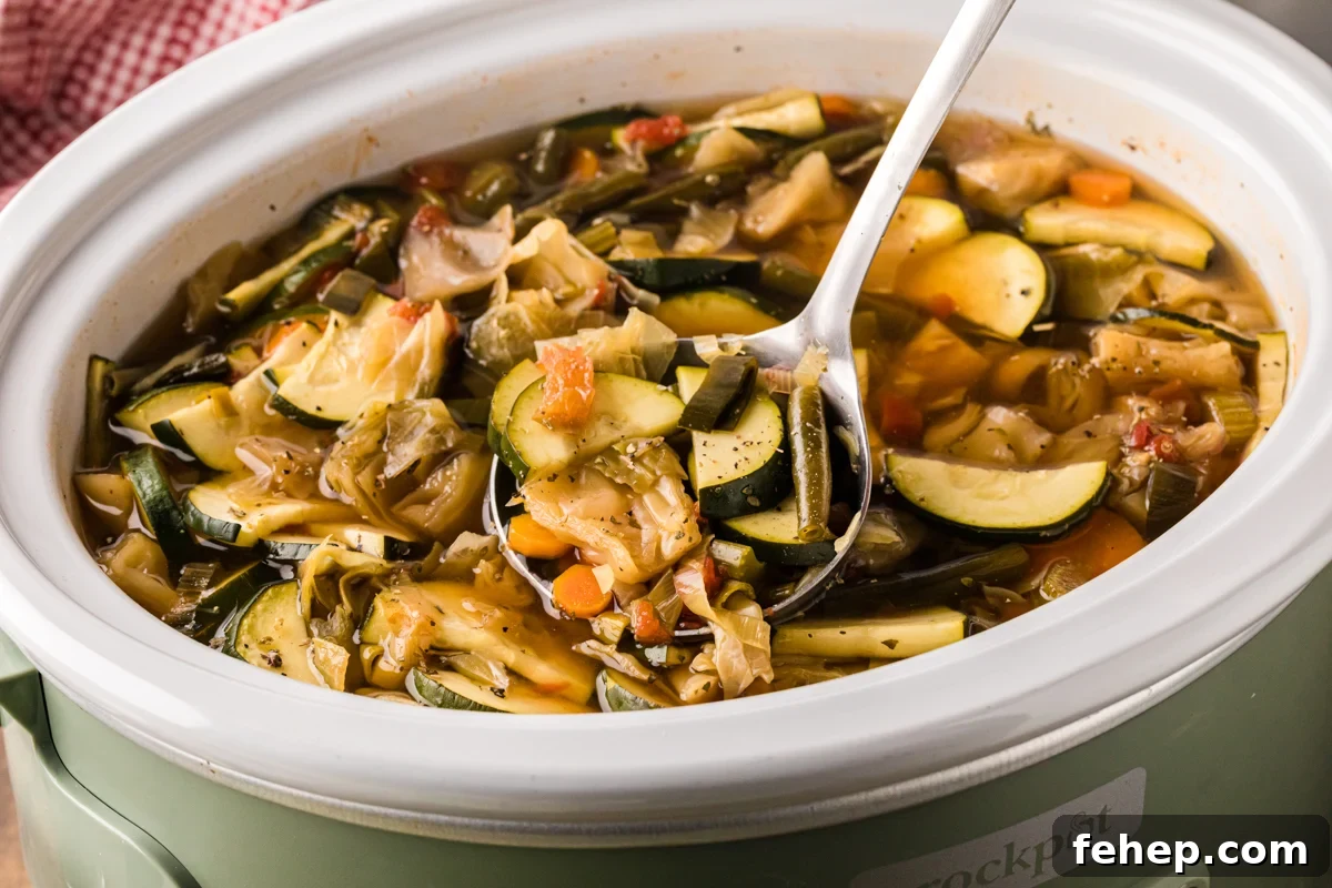 A ladle scooping out some slow cooker weight loss soup.