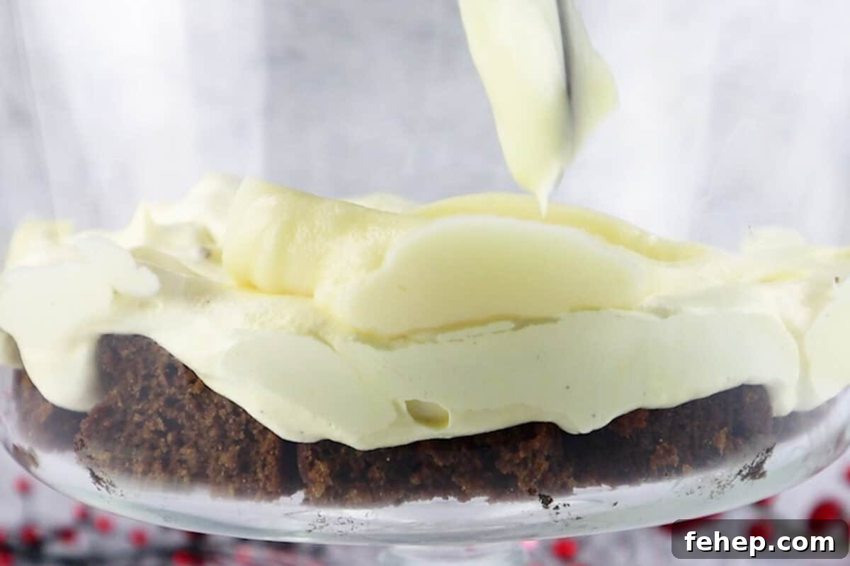 Gingerbread Trifle Recipe: Festive Layered Dessert for Holidays 15 adding first layer of white chocolate pudding over the eggnog layer in the trifle dish.