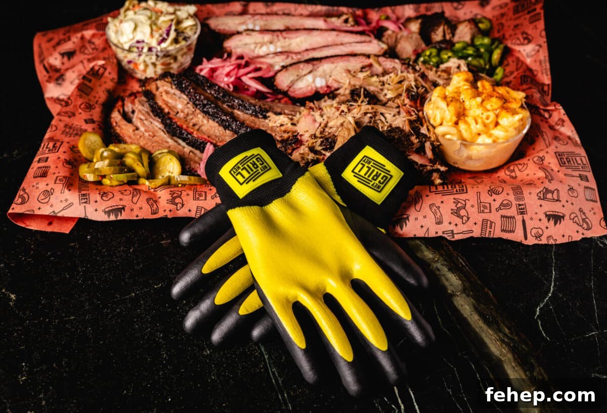 Perfect BBQ Gift Ideas for the Grillmaster This Season 4 A pair of Hey Grill Hey Pitmaster gloves resting against a platter of grilled meats.