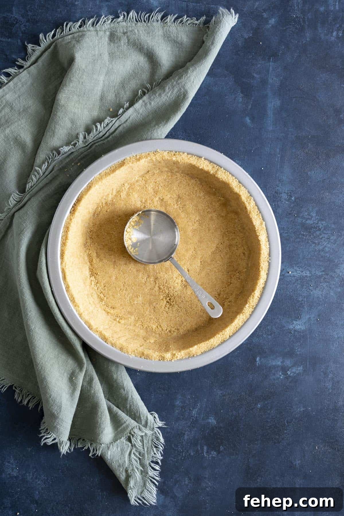Vanilla Wafer Crust Recipe: Quick No-Bake Pie and Cheesecake Crust 7 A vanilla wafer crust with a measuring cup inside the crust.