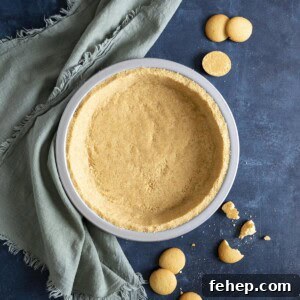 Vanilla Wafer Crust Recipe: Quick No-Bake Pie and Cheesecake Crust 9 A vanilla wafer crust on a blue table top next to a green towel and vanilla wafer cookies all around.