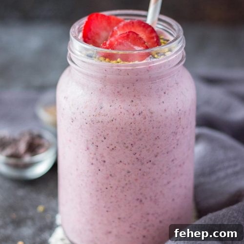 Strawberry Kefir Smoothie topped with fresh strawberries and superfoods