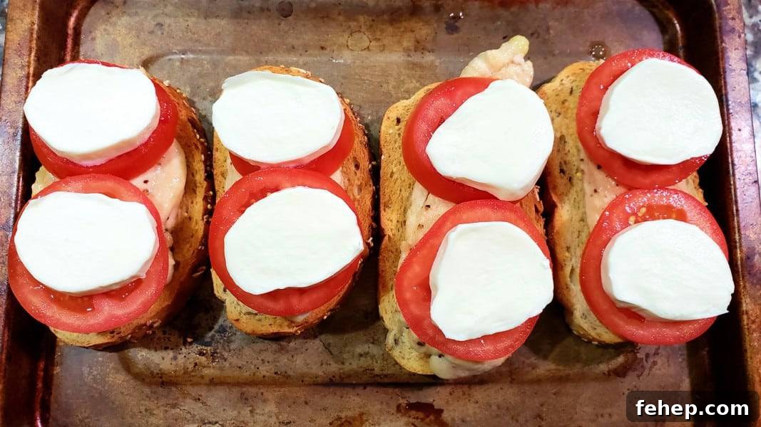 toast, chicken, and tomatoes topped with mozzarella slices.