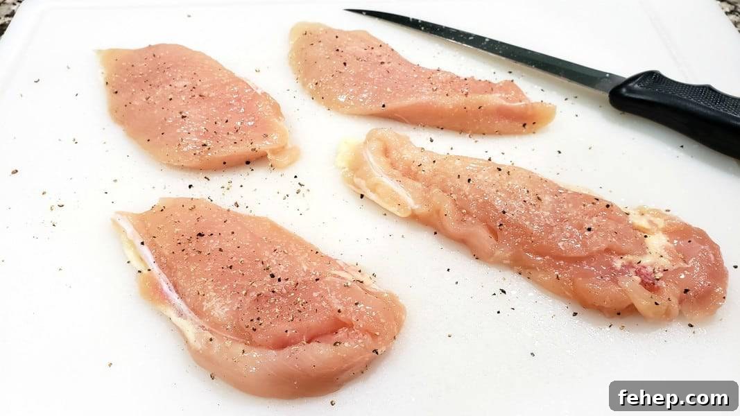 four pieces of boneless chicken seasoned with salt and pepper.