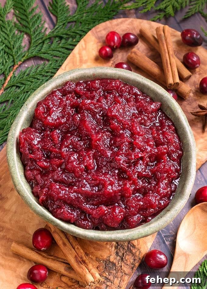 Cranberry Sauce in a green bowl with greenery around