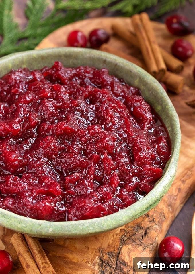 Cranberry Sauce in a green bowl on a wooden plank