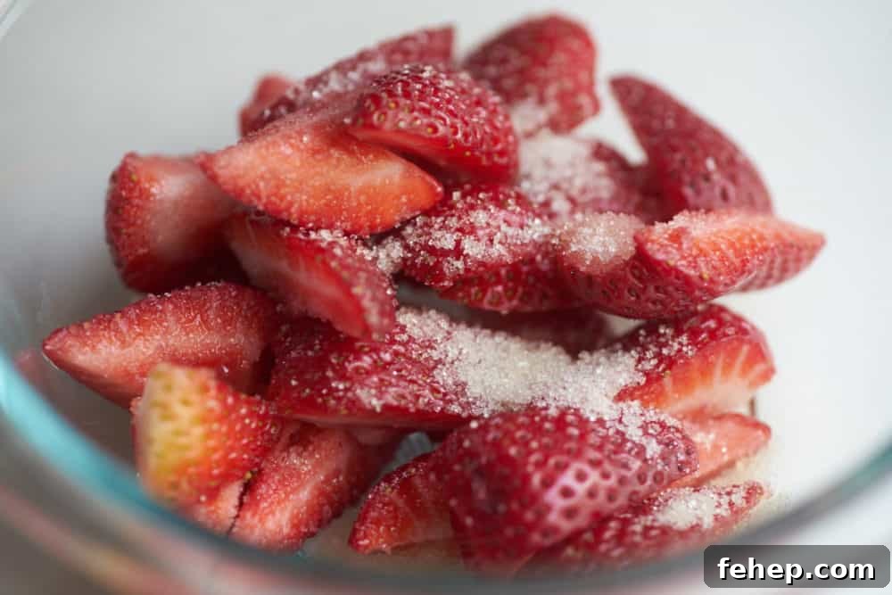 Creamy Dairy-Free Strawberry Milkshake Recipe 4 Fresh strawberries dusted with sugar in a glass bowl.