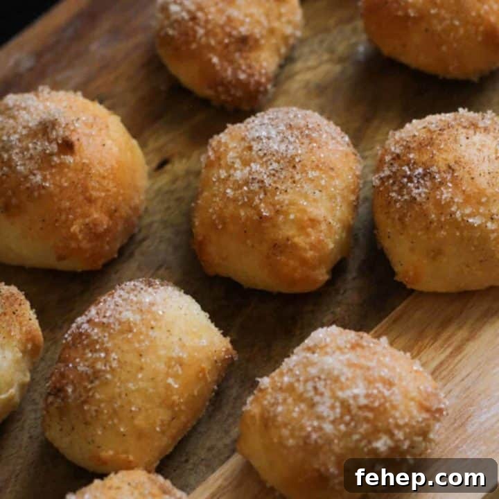 pretzel bites covered in cinnamon sugar on a wooden board.