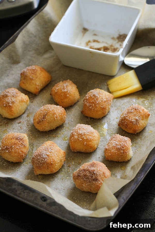Cinnamon Sugar Pretzel Bites (Yeast-Free) 8 pretzel bites covered in cinnamon sugar on a baking tray.
