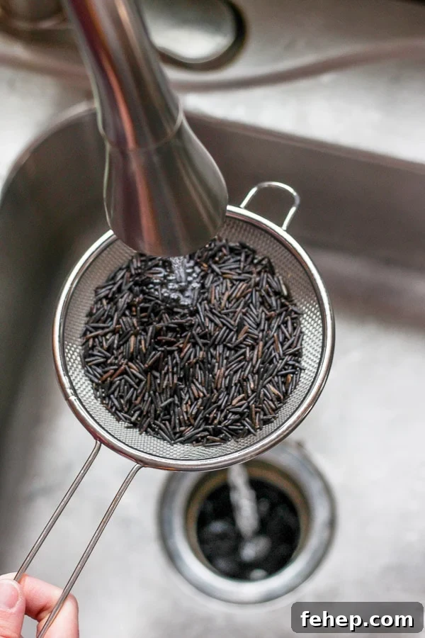 Wild rice being rinsed under cold running water.