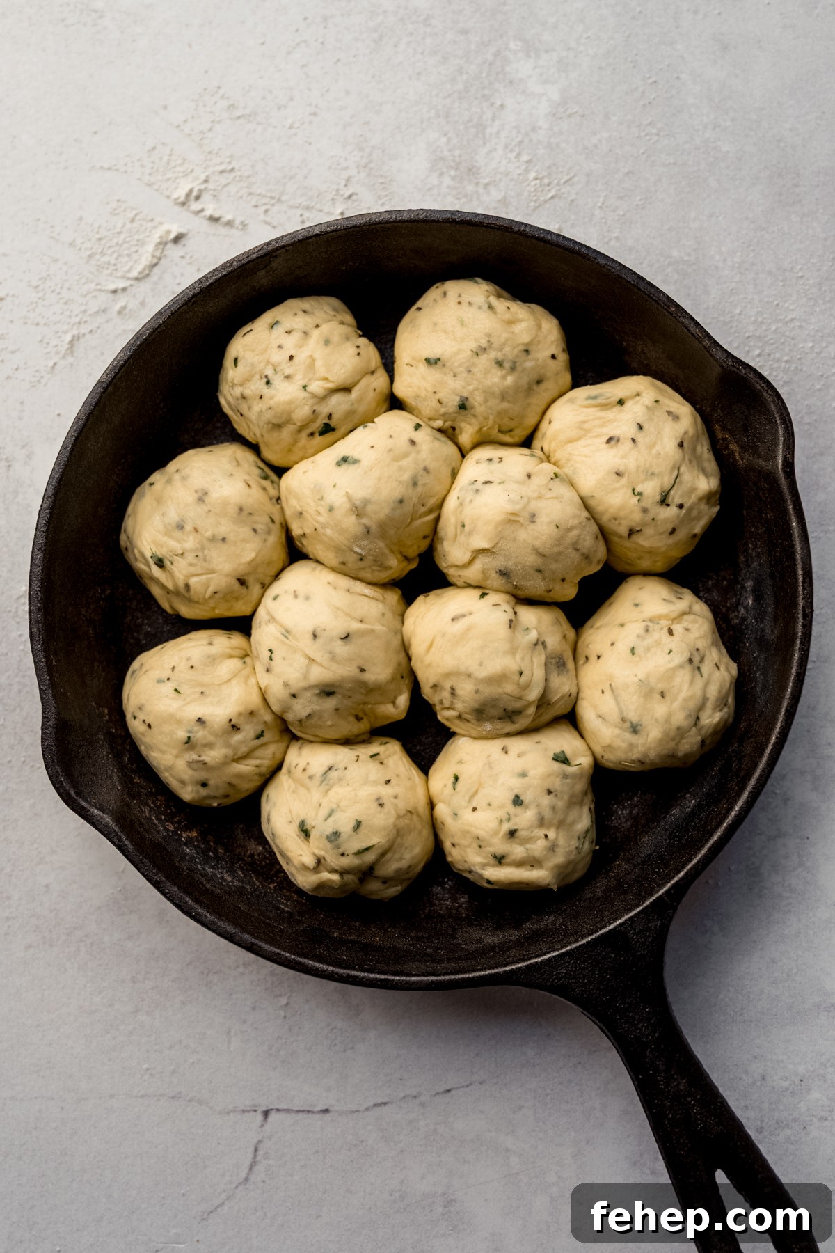 Aerial photo of a skillet with herbed dinner rolls in it.