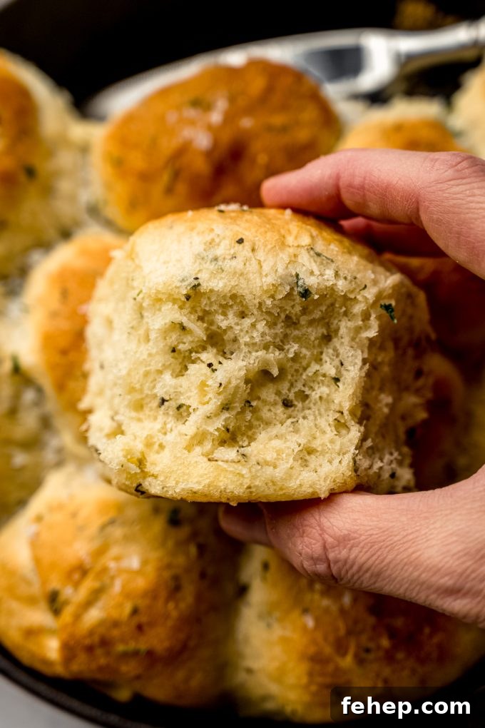 Someone is holding an herbed skillet roll.