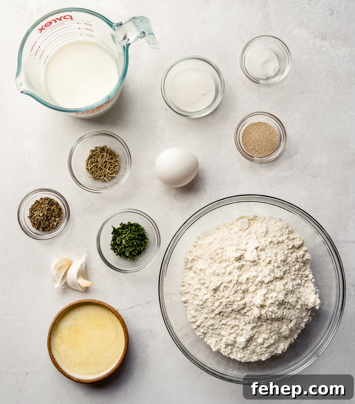 Aerial photo of ingredients to make herbed skillet rolls on a surface.