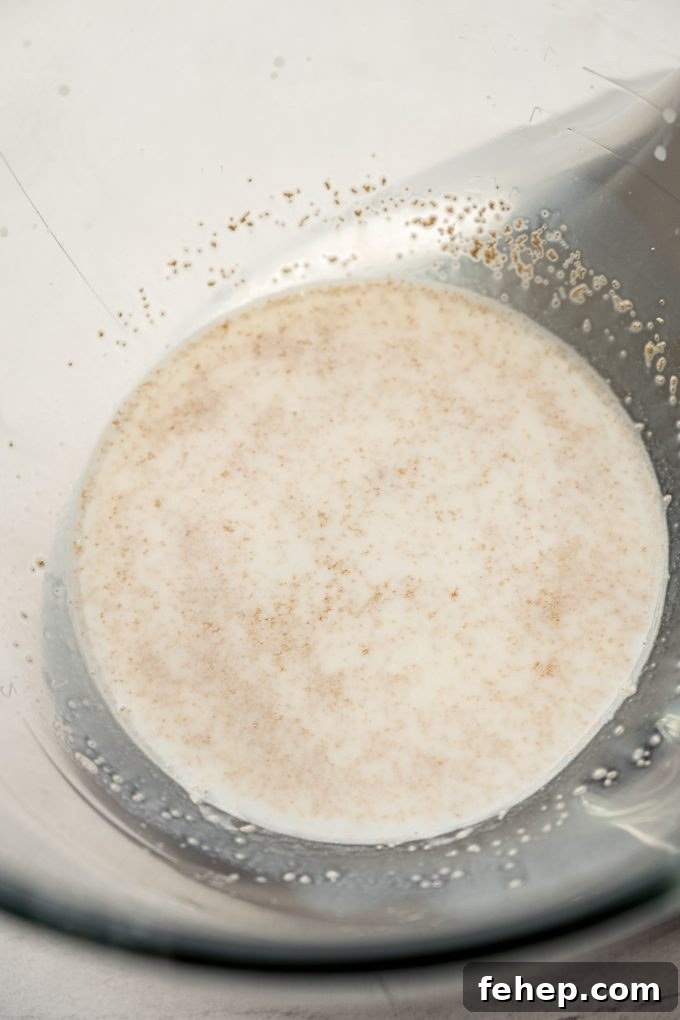 Yeast that has been activated in the bottom of a bowl of a stand mixer.