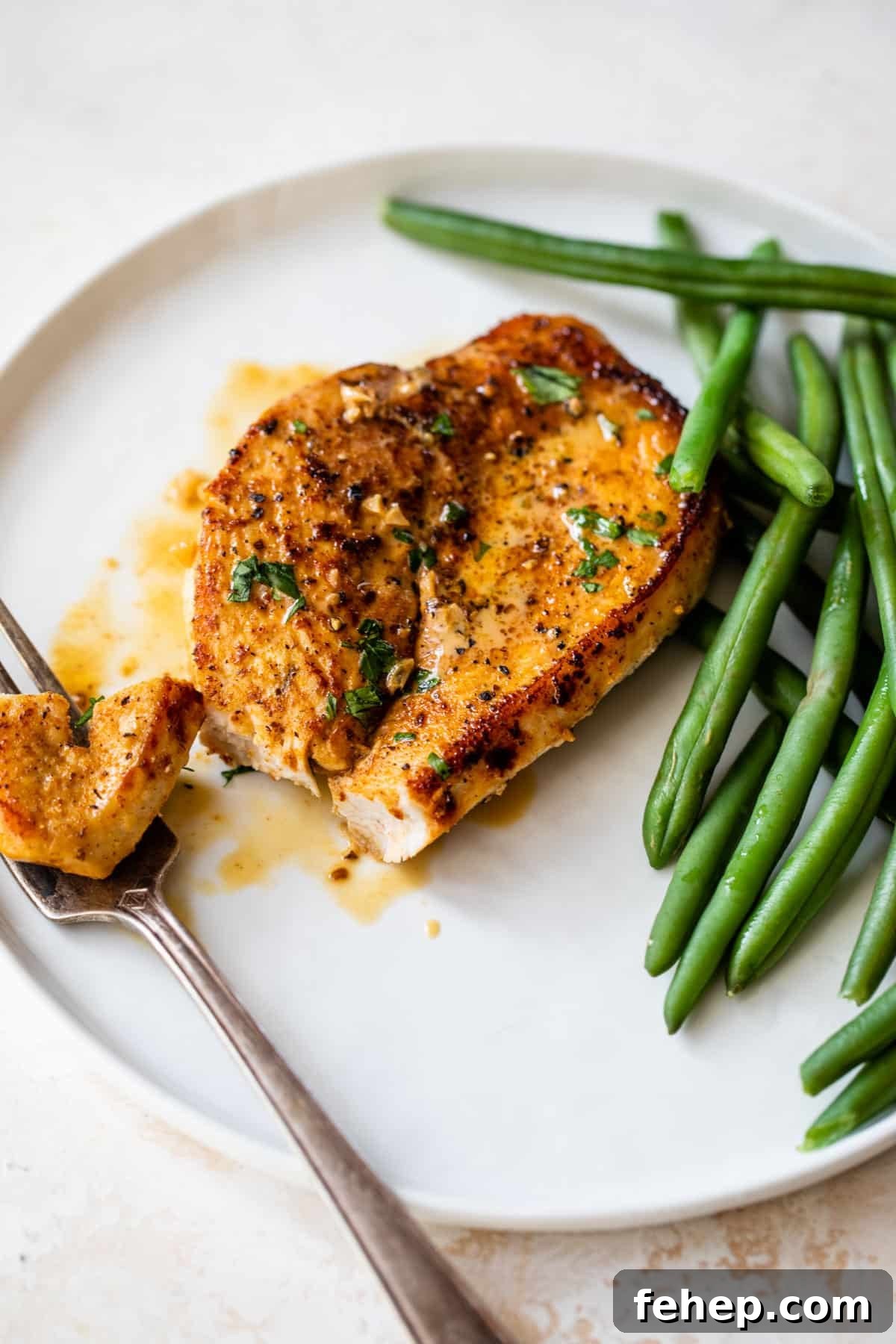 cajun chicken on a plate with a fork and green beans