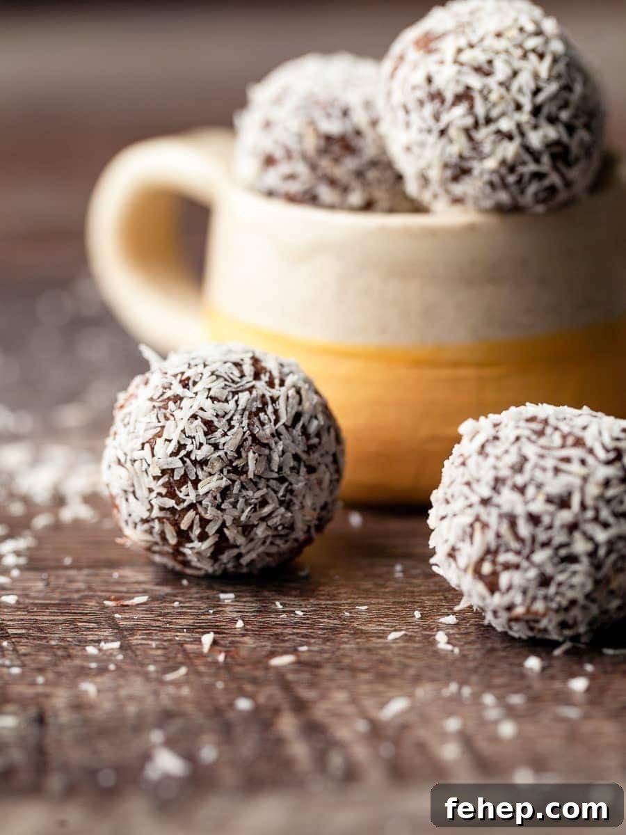 gluten free rum balls coated in coconut on a brown woodface