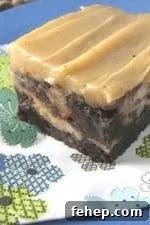 Caramelized Roasted Banana Swirl Brownies with Gooey Chocolate 2 Caramelized Roasted Banana Brownies with Peanut Butter Sweet Cream Frosting on top. The brownie is sitting atop a flower-decorated napkin on a blue plate.