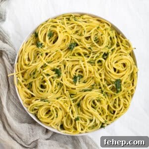 spinach pesto pasta swirled in a white serving bowl