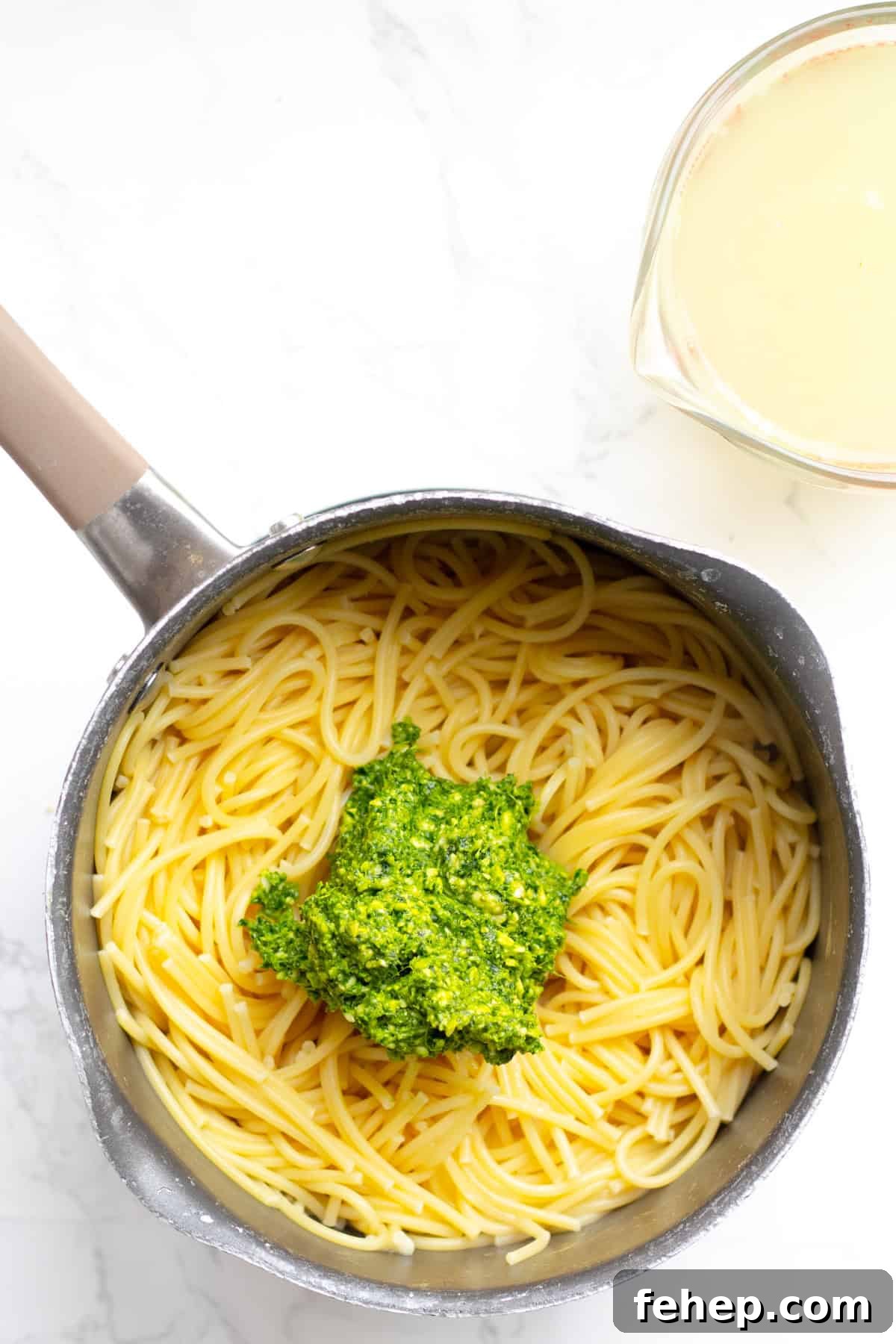 spinach pesto on top of pasta in a pot