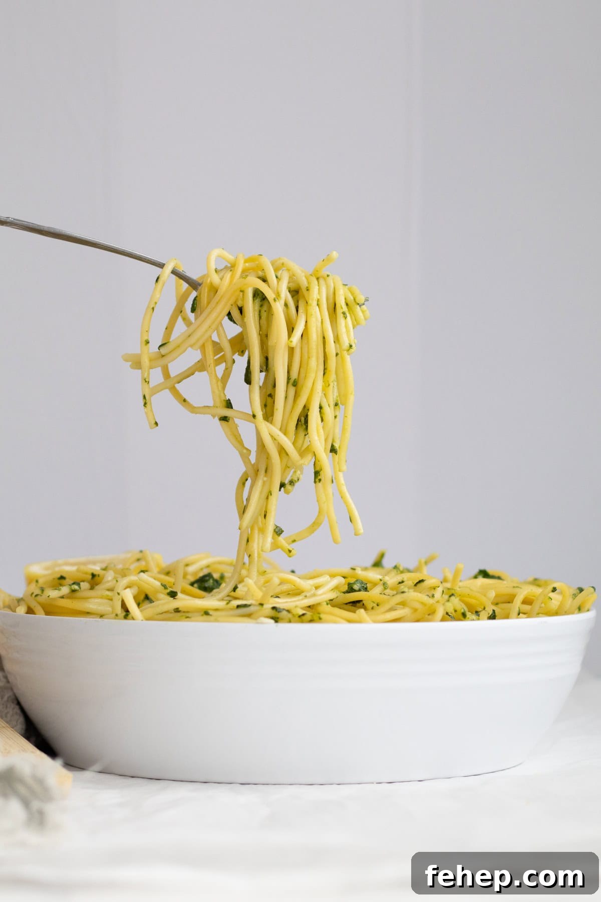 spinach pesto pasta in a white serving dish.