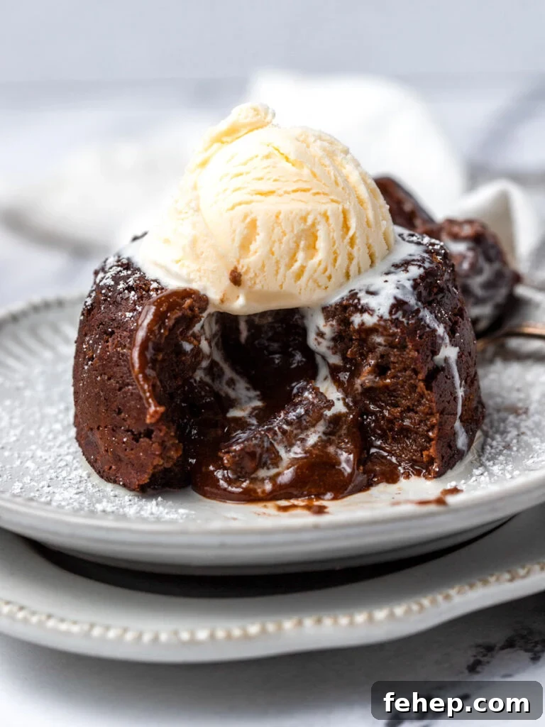 A lava cake cut opened with a scoop of ice cream on top.