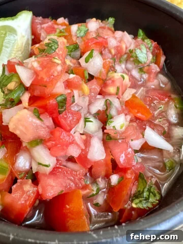 Homemade pico de gallo in a bowl with lime.
