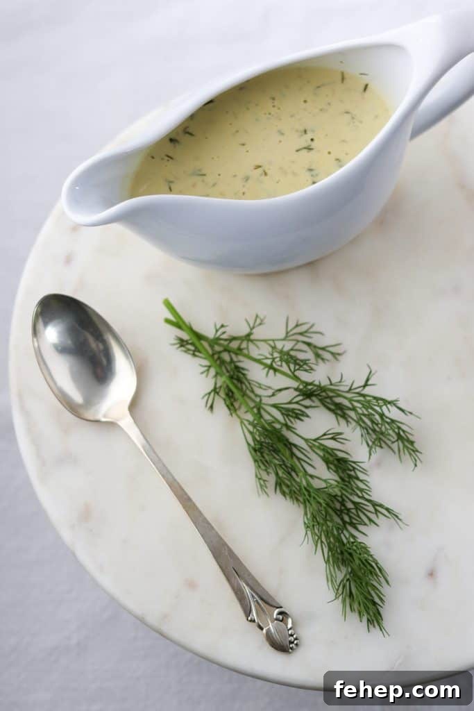 Modern Scandinavian Christmas Eve Smorgasbord Menu Ideas 7 Creamy mustard dill sauce in a gravy boat with a spoon and fresh dill on a marble surface