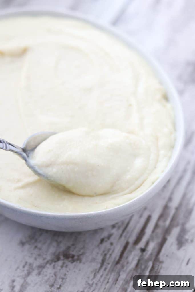 Modern Scandinavian Christmas Eve Smorgasbord Menu Ideas 8 A bowl of potato and celery root puree with a spoon on a wooden surface