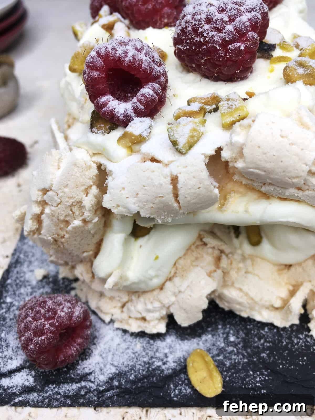 15 Irresistible Cake Recipes for Every Occasion 12 Decorated rosewater meringue roulade on a black serving board with plates in the background