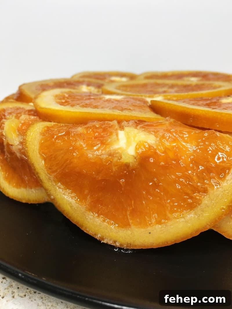 15 Irresistible Cake Recipes for Every Occasion 14 Cake covered with caramelized oranges on a black plate: Close up