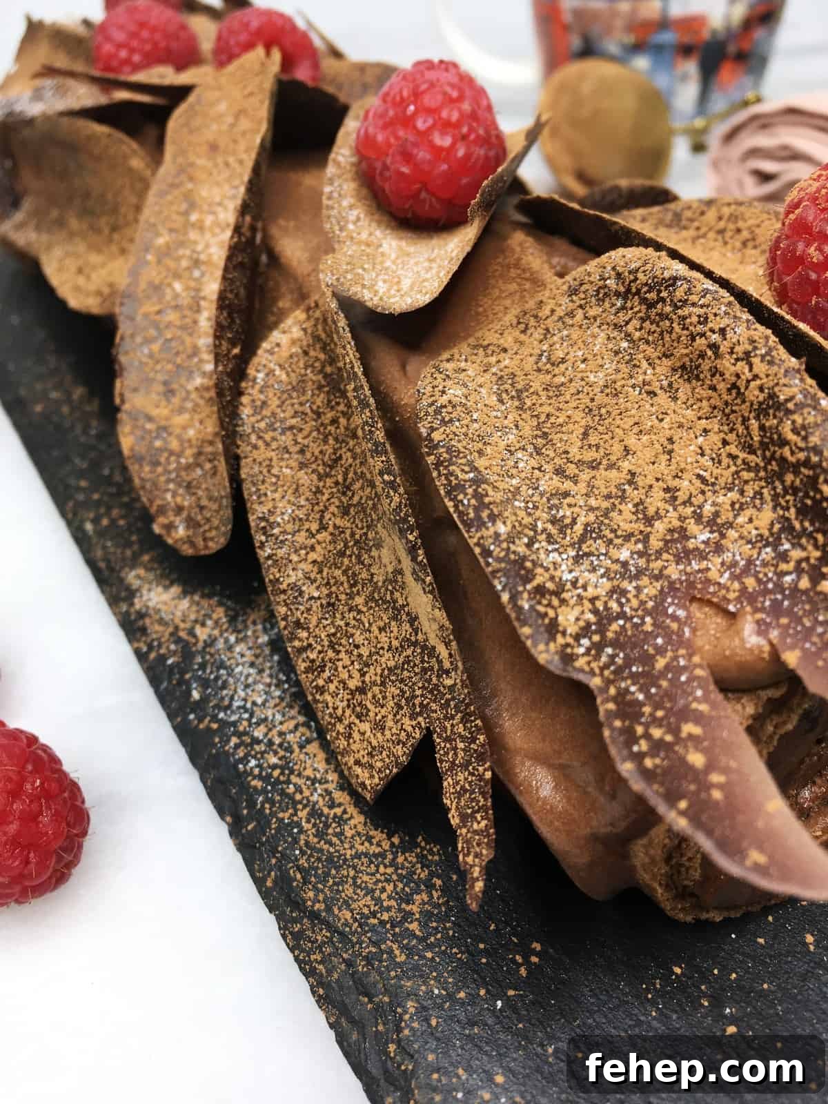 15 Irresistible Cake Recipes for Every Occasion 8 Chocolate raspberry roll cake on a slate board; a cup and berries in the background
