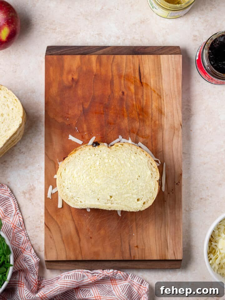 Gruyère Grilled Cheese with Fig Jam and Apple Slices 9 fully assembled sandwich on a wood cutting board, uncooked