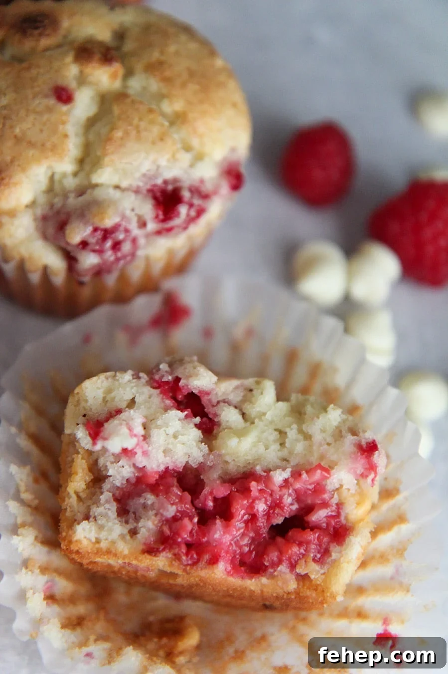 White Chocolate Raspberry Muffins Recipe with Luscious Berry Swirls 4 a muffin sliced in half up close.