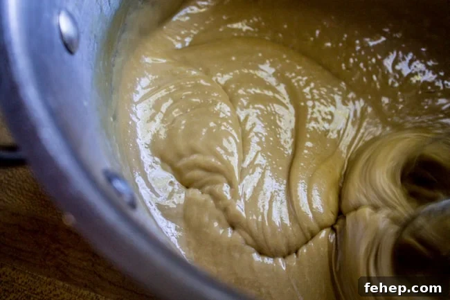 beating brown sugar frosting with a mixer.