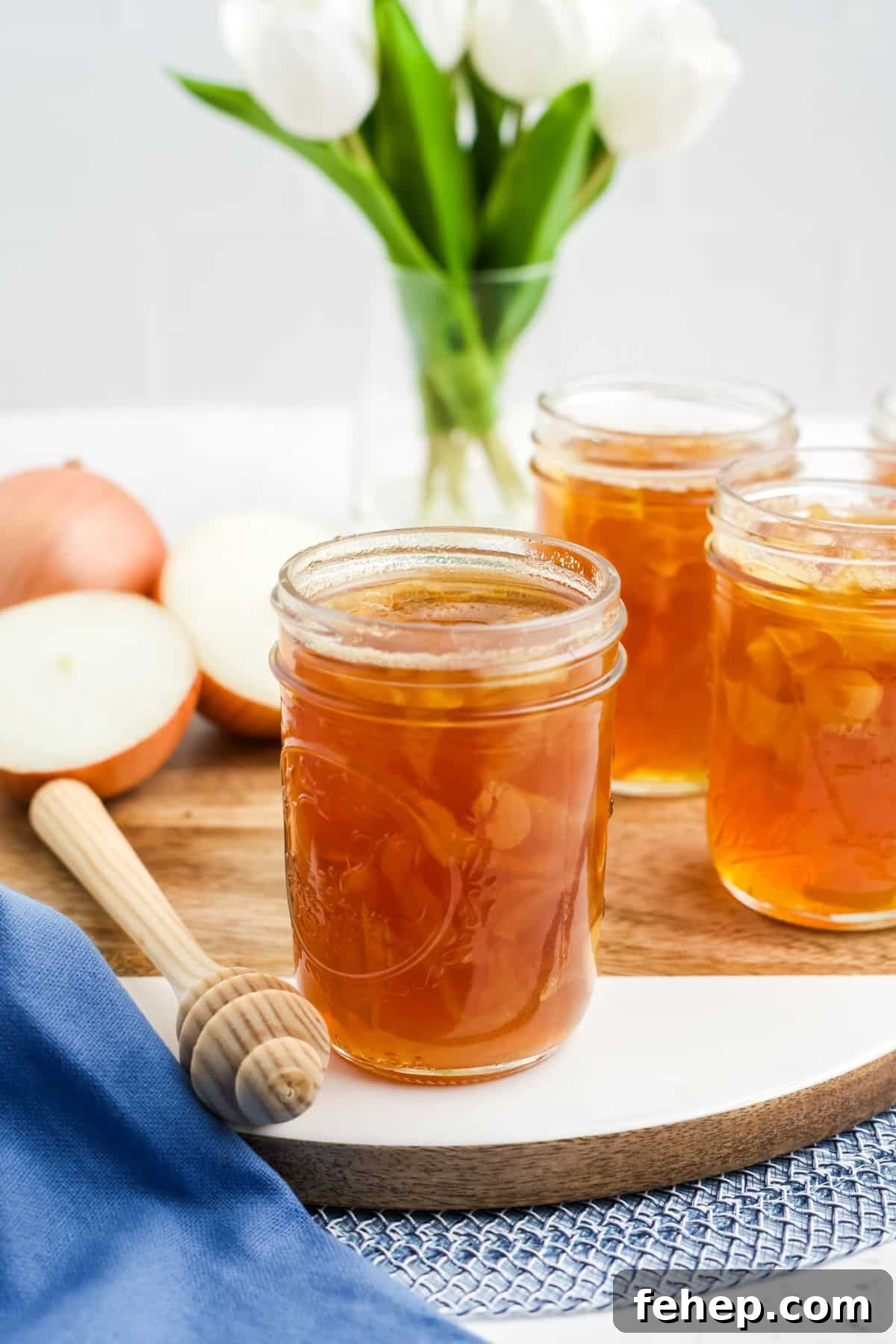 Homemade Honey and Onion Cough Syrup Recipe for Quick Relief 2 A jar of honey onion syrup on the table with onions in the background and more jars.
