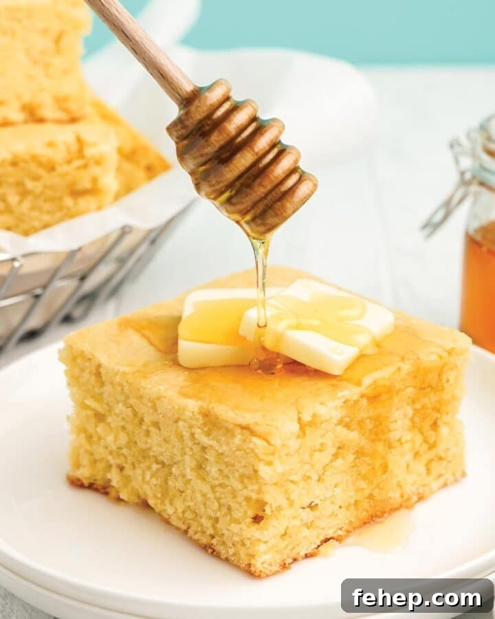 Drizzling honey over the top of a piece of cornbread with honey.