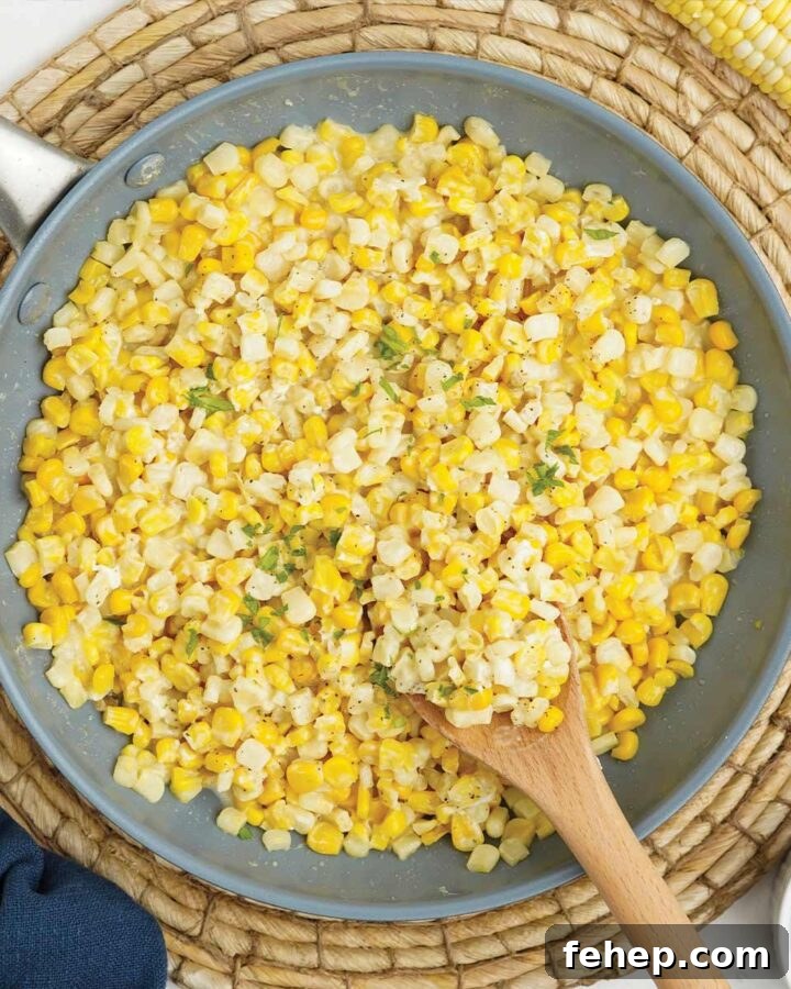 Skillet of honey butter corn with wooden spoon.