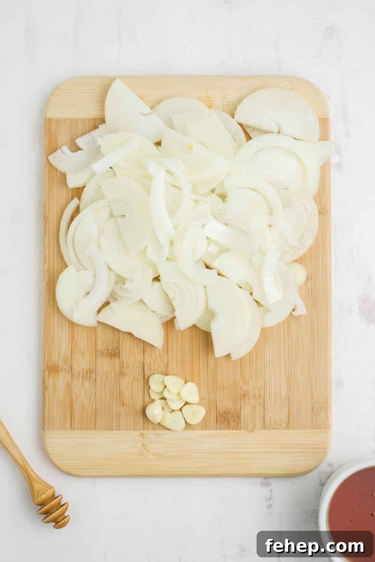Homemade Honey and Onion Cough Syrup Recipe for Quick Relief 4 Onion and garlic chopped on a cutting board.