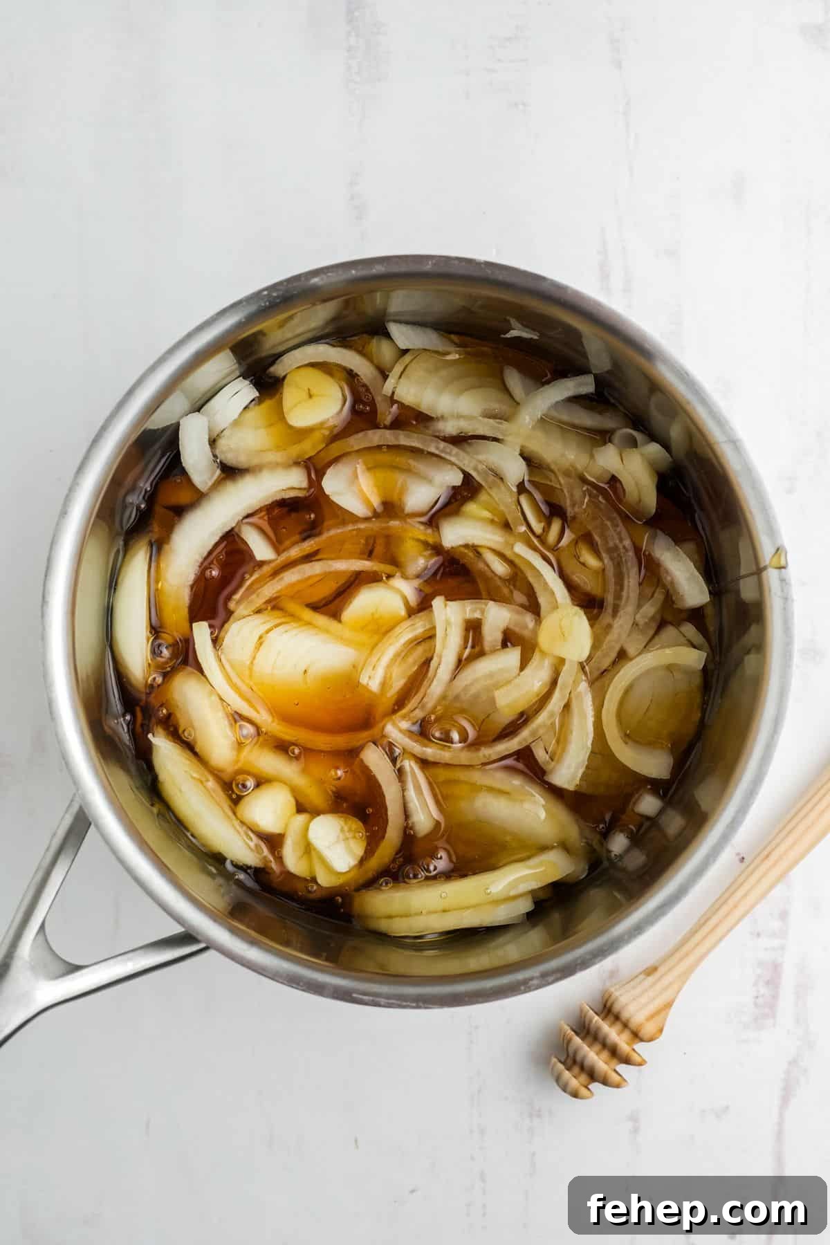 Homemade Honey and Onion Cough Syrup Recipe for Quick Relief 5 Ingredients combined in a saucepan.