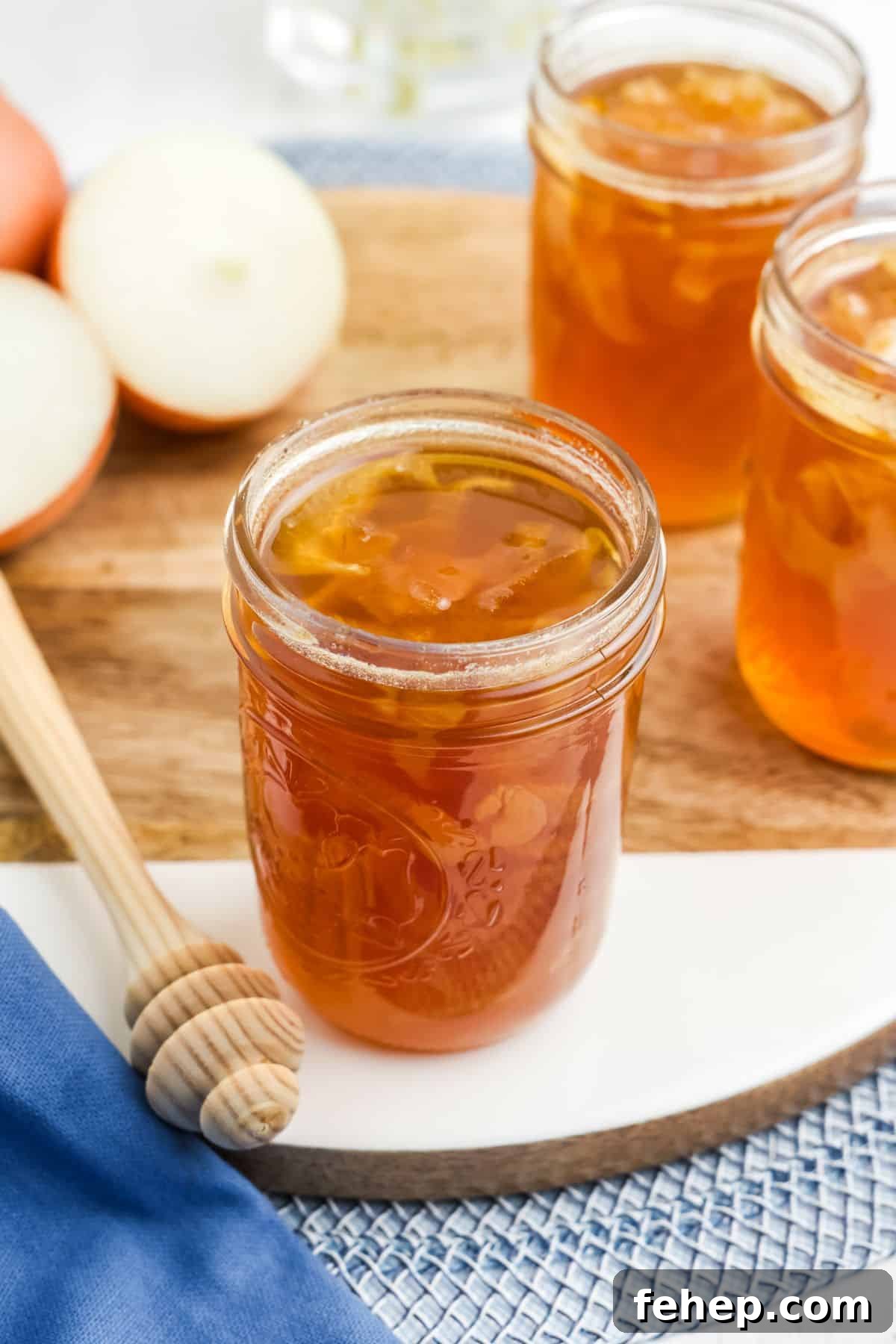 Homemade Honey and Onion Cough Syrup Recipe for Quick Relief 8 Jars of garlic and onion syrup on the table on a round wooden cutting board.