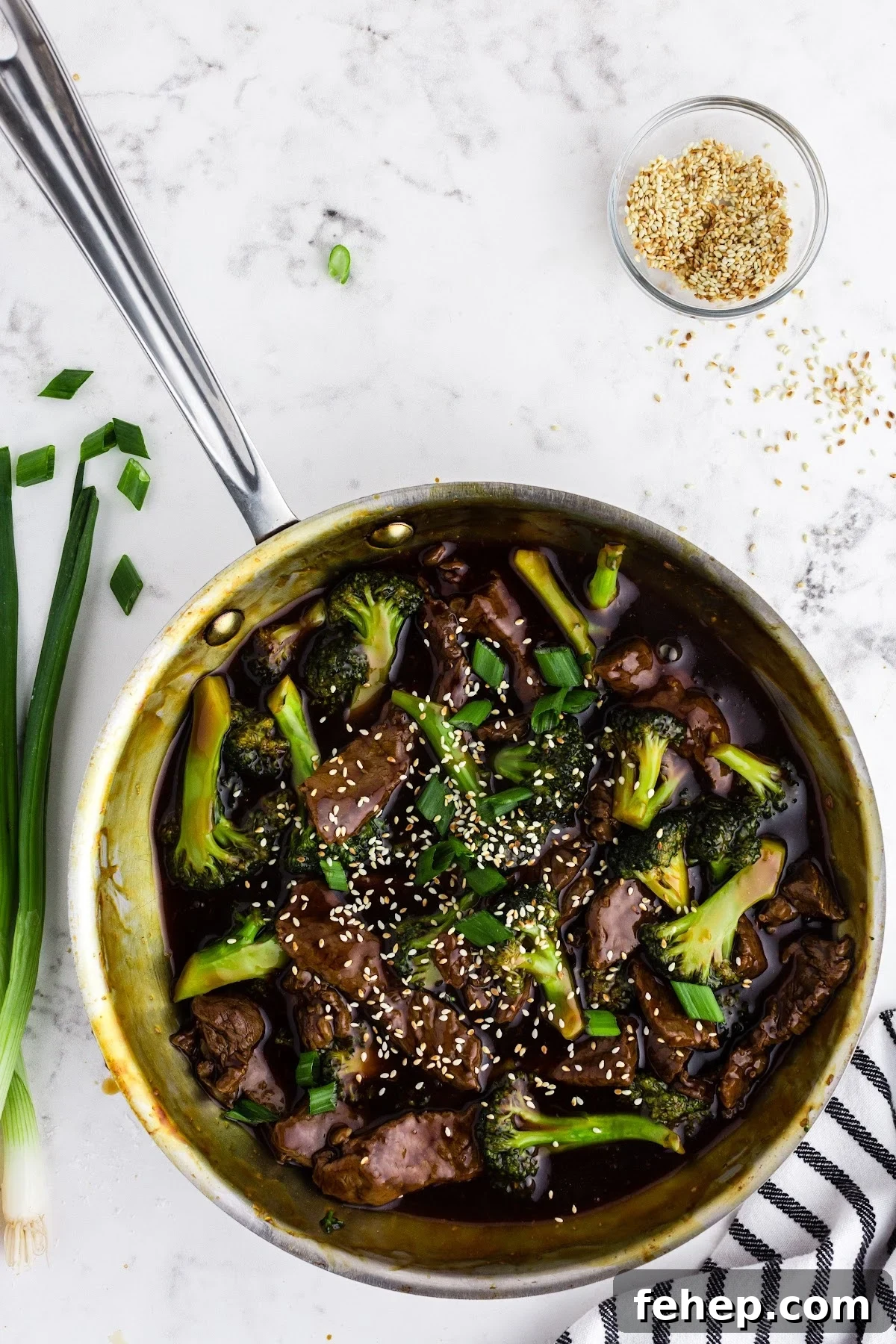 Panda Express Beef and Broccoli Recipe (Copycat Version) 11 Cooked Panda Express beef and broccoli recipe in skillet with chopped shallots and toasted sesame seeds.