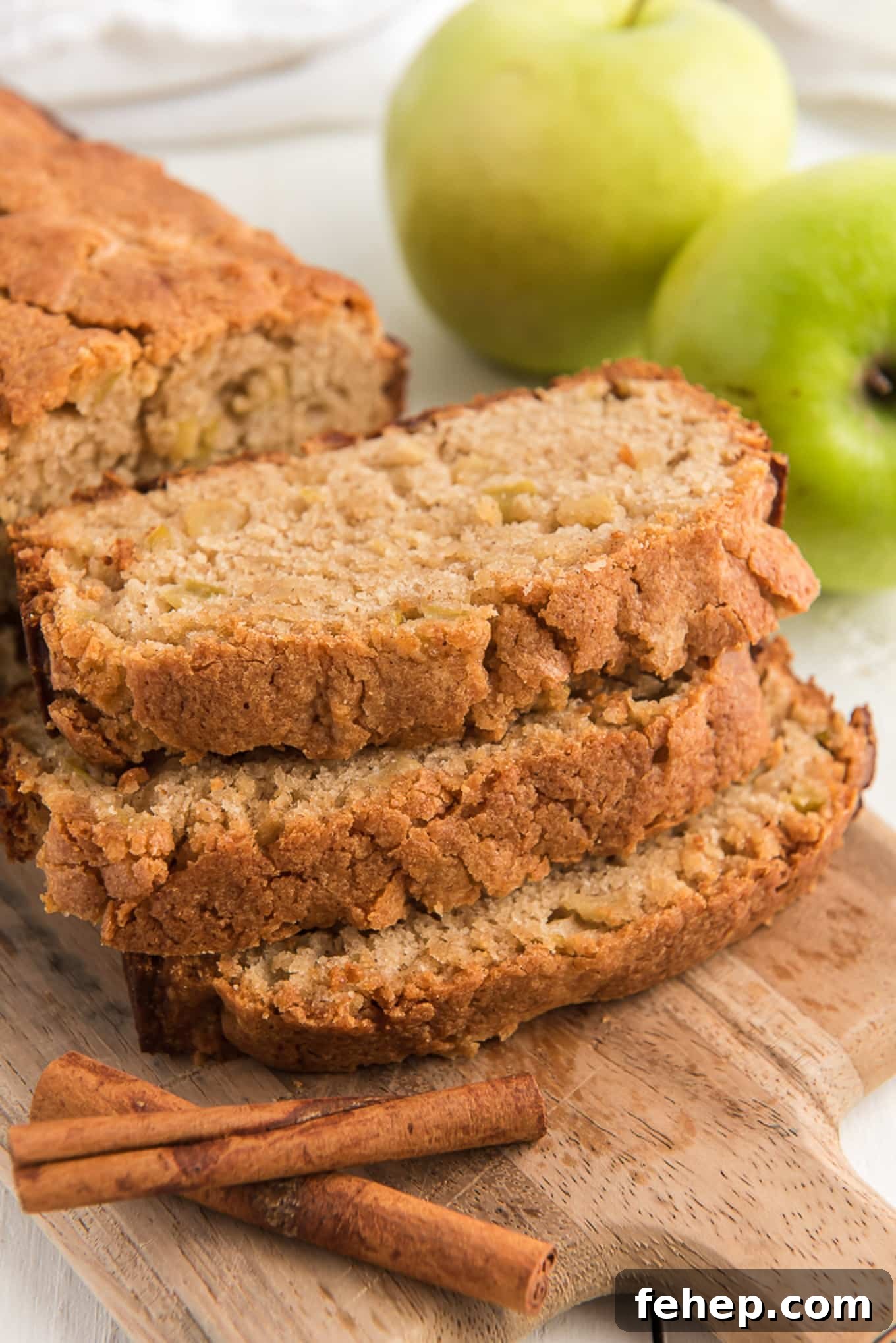 Moist Homemade Apple Bread Recipe with Cinnamon Sugar Swirl 6 Slices of apple bread on a cutting board in front of the rest of the loaf.