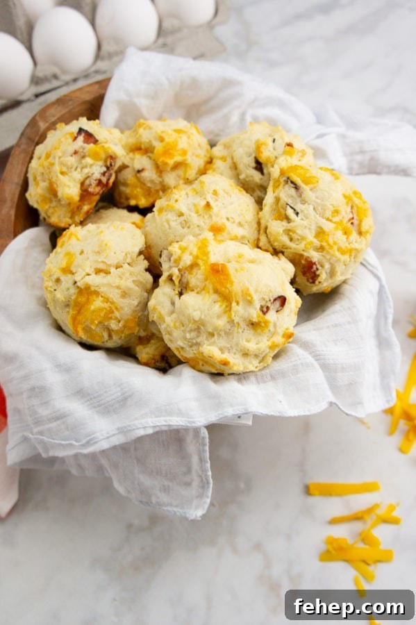 Savory Ham and Cheese Biscuit Recipe for Breakfast or Brunch 2 a bowl of ham and cheese biscuits next to eggs on a white surface