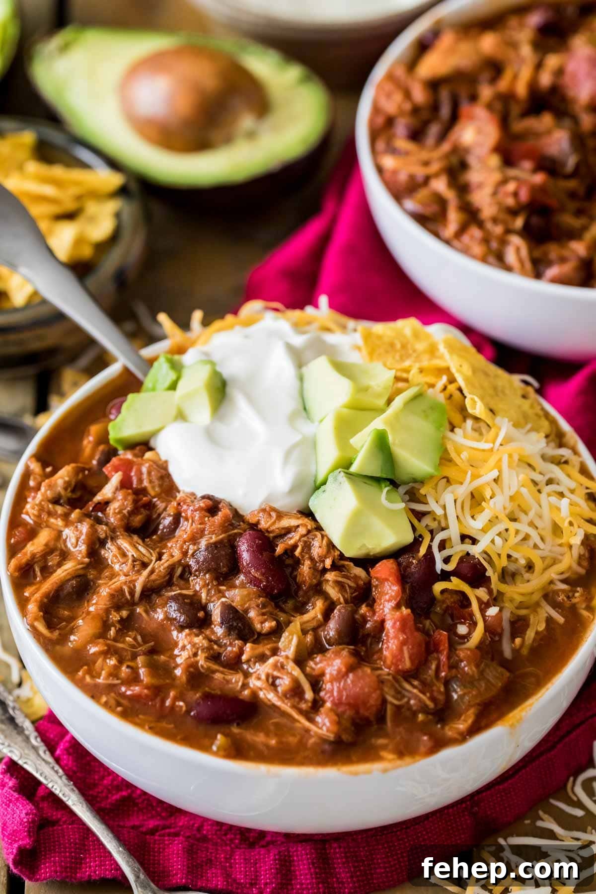 Leftover Turkey Chili Recipe: Comforting One-Pot Meal 2 Bowl of turkey chili topped with sour cream, avocado, and shredded cheese.