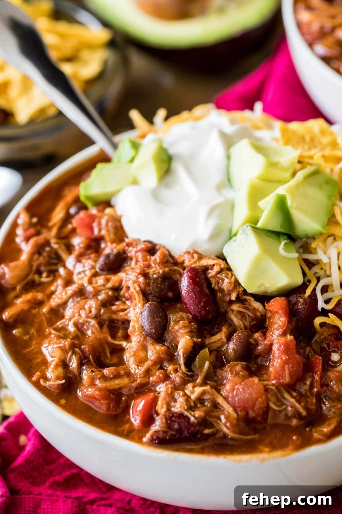 Leftover Turkey Chili Recipe: Comforting One-Pot Meal 5 Bowl of chili topped with sour cream, avocado, and shredded cheese.