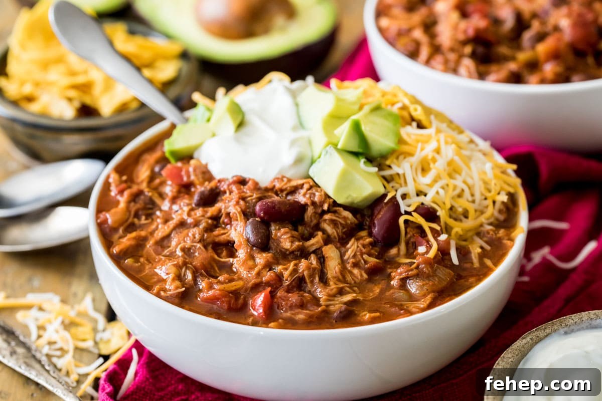 Leftover Turkey Chili Recipe: Comforting One-Pot Meal 6 Bowl of chili topped with sour cream, avocado, and shredded cheese.